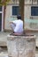 Jewish boy in Kippah sitting on an old well at Campo de Ghetto Novo, Venice, Italy