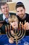 Jewish family lighting Chanukah menorah