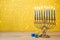 Jewish Hanukkah background with vintage menorah and spinning top dreidel over lights bokeh