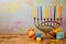 Jewish holiday Hanukkah celebration with menorah, dreidel, gifts and oil jug