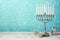 Jewish holiday Hanukkah celebration with menorah, dreidel and gifts on wooden table