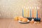 Jewish holiday Hanukkah celebration with menorah over bokeh background. Retro filter effect