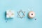 Jewish holiday Hanukkah concept - Hanukkah sweet doughnut with powdered sugar and fruit jam, gift boxes on blue paper background