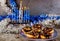 Jewish holiday Hanukkah. Menorah with burning candles and sweet donuts with chocolate and sprinkle on the top