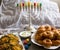 Jewish holiday Hanukkah symbols against white background; traditional spinning top, menorah traditional candelabra, `Sfinj `Donu