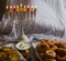 Jewish holiday Hanukkah symbols against white background; traditional spinning top, menorah traditional candelabra, `Sfinj `Donu
