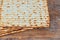Jewish kosher matzah closeup on paper on a wooden table. horizontal view