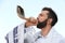 Jewish man in kippah and tallit blowing shofar outdoors. Rosh Hashanah celebration