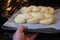 Jewish man puting uncooed Challah Bread in the oven