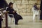 Jewish man sitting on a chair and holding bible book, praying at the sacred Wailing Wall, Western Wall, Jerusalem