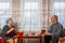 Jewish married couple in headdresses at home at the table a man writes his wife knits on knitting needles.