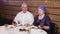 A Jewish married couple a wife in a headdress and a man in a kippah are having dinner in the room at the table