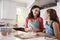 Jewish mother and daughter plaiting dough for challah bread