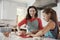 Jewish mother and daughter rolling dough for challah bread