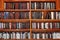 Jewish prayer books on wooden shelves.