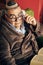 Jewish senior with glasses in the armchair reading a torah book