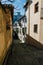 Jewish street in Granada, Spain, at noon with harsh light and Alhambra palace fortress in the back