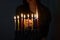 Jewish Woman lighting Hanukkah Candles in a menorah.