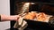 Jewish woman taking out baked Challah Bread out of the oven