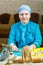 A Jewish woman in a traditional headdress bakes gomentashi cookies for Purim.