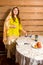 A Jewish woman in a wig and a scarf falling from her head standing at the table lights candles in honor of the holy