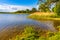 Jezioro Selmet Wielki lake landscape with reeds and wooded shoreline in Sedki village in Masuria region of Poland