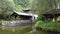 Jiangwan in Wuyuan County, Jiangxi Province, China. Old building in a garden with trees and a pond.