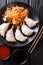 jiaozi, gyoza dumplings stuffed with shrimps with fresh vegetable salad close-up on a plate and soy and tomato sauces. Vertical t