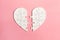 Jigsaw puzzle heart split in two pieces isolated on pink background, top view, flat lay, divorce, depression and breakup concept,