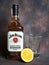 Jim Beam whiskey bottle, half lemon and a glass for whiskey on dark vintage background