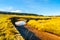 Jizerka stream on green meadow with old small stone bridge, Jizerka village, Jizera Mountains, Czech Republic