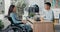 Job interview with disabled woman in wheelchair, stern male boss of Asian-Korean beauty asks questions