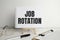 JOB ROTATION text on notebook with pen and table