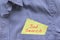 Job search, words in red on a yellow paper stuck out from blue shirt pocket