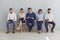 Job seekers with resumes in hands waiting for job interview sitting on chairs in a row