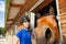 Jockey girl with her funny horse looking at camera