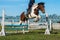 Jockey on her horse leaping over a hurdle