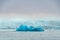 Joekulsarlon Glacier Lagoon motor boat in front of giant iceberg in deep blue