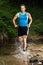 Jogger running through a streambed