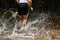 Jogger running through a streambed