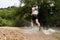 Jogger running through a streambed