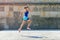 Jogger woman jump by the wall in city.