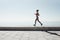 Jogging athlete young woman running at sea background