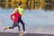 Jogging Concepts. Running Couple While Training Outdoors on Road At River For Durable Marathon Pretty Young Female and Extremely