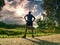 Jogging tall sports man in trees shadows with sun light behind