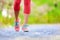Jogging woman with athletic legs and running shoes