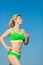 Jogging. Young sportswoman in green sportswear running outdoors