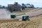 John Deer 8R340 tractor pulling a Brent 1196 grain cart while transfering corn from a John Deer S780 harvester
