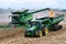 John Deer 8R340 tractor pulling a Brent 1196 grain cart while transfering corn from a John Deer S780 harvester