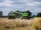 John Deer combine unloading harvested field corn for transport